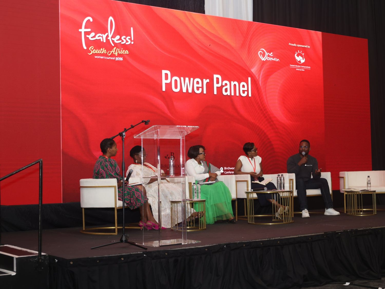 Five panellists on stage under a Power Panel screen