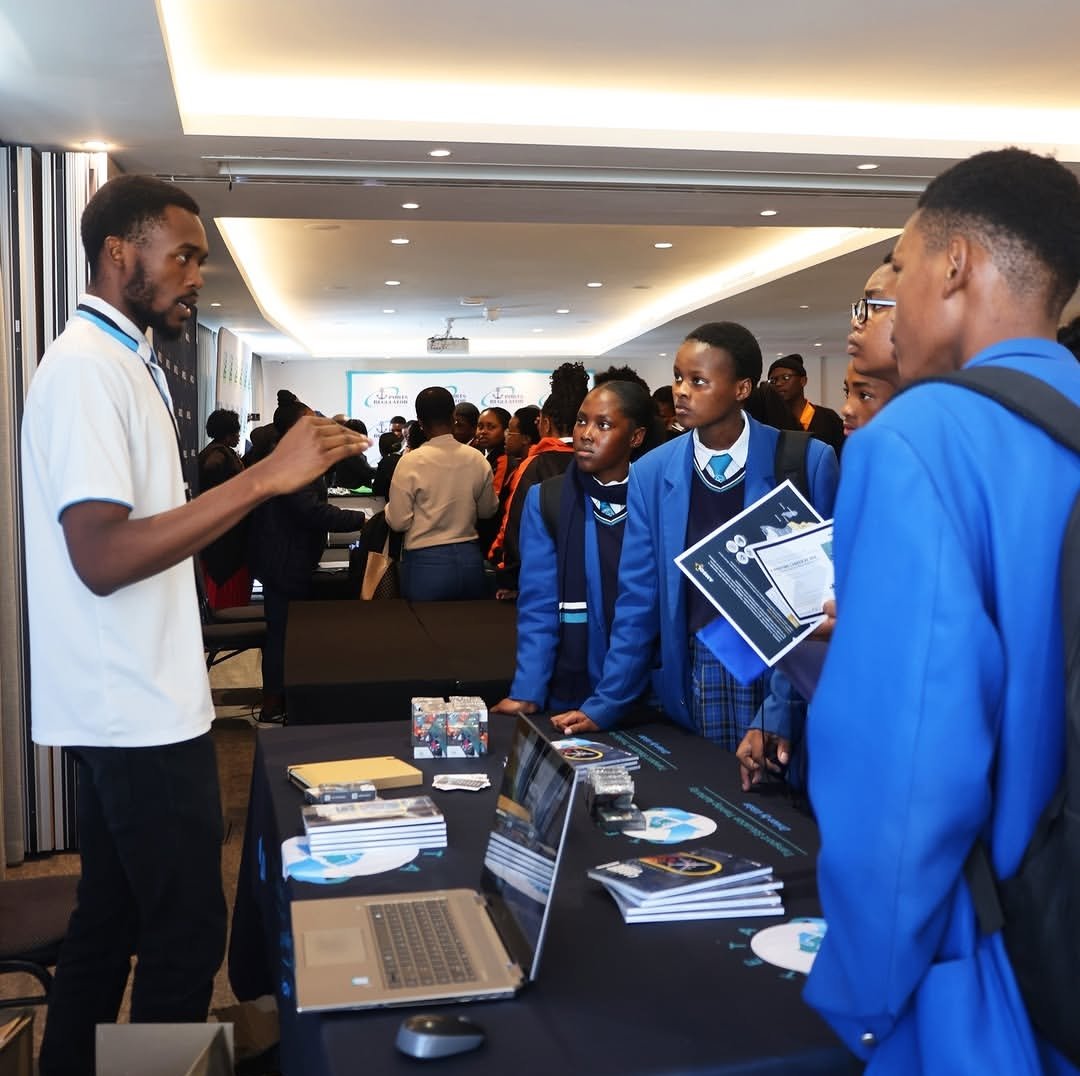 Wandii talking school learners through TETA material at an exhibition stand