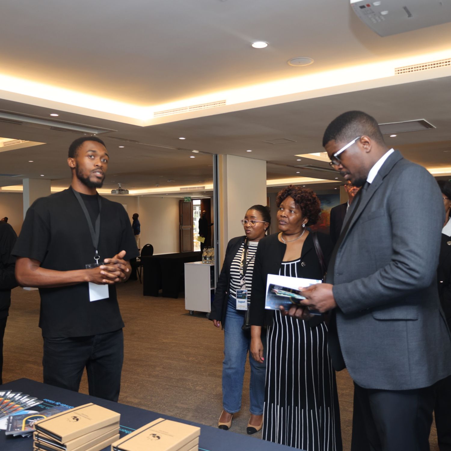 Wandii talking guests through TETA material at an exhibition stand