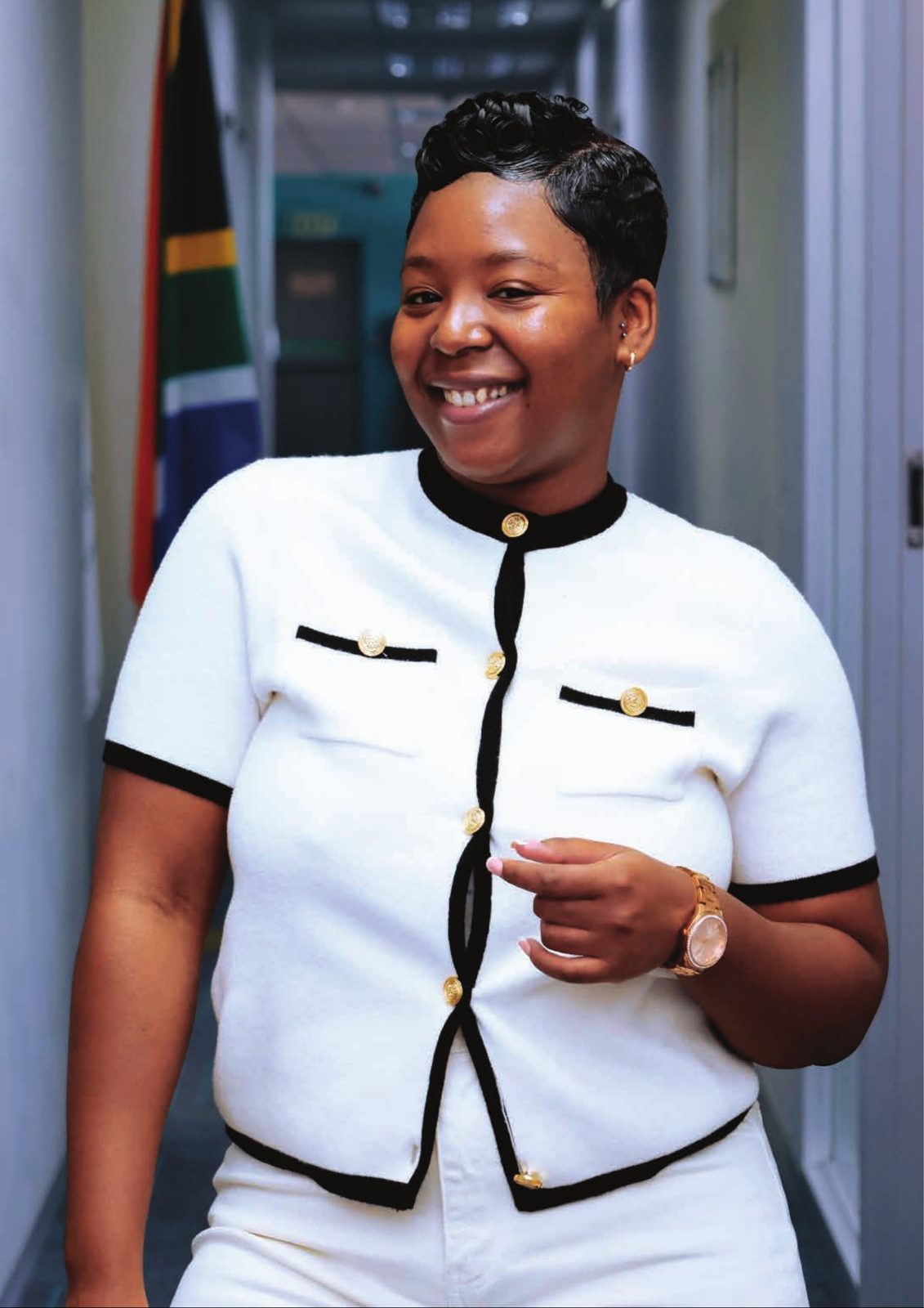 Smiling woman in a white cardigan in an office corridor